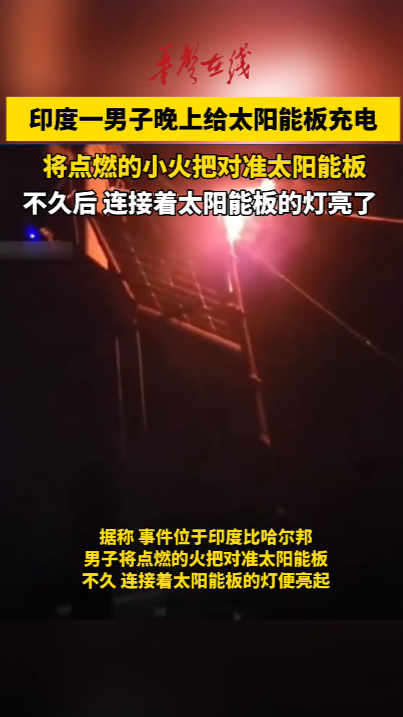 印度男子晚上举火把给太阳能板充电