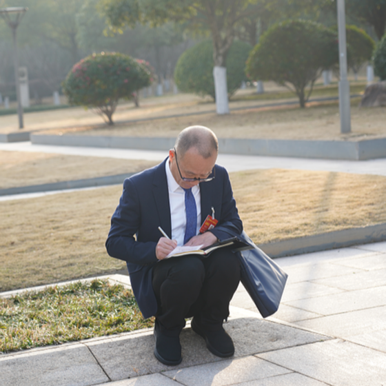 在现场｜会议开幕前，这名省政协委员为何在花坛边席地而坐？